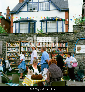 Les visiteurs la lecture de livres, la navigation sur les étagères et assis à l'extérieur de l'honnêteté des tables de café à Hay-on-Wye au Pays de Galles UK KATHY DEWITT Banque D'Images