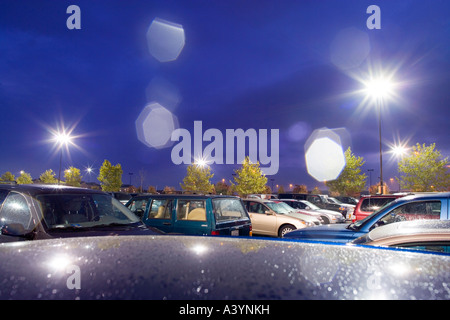 Parking du supermarché, parking sous la pluie dans la nuit. Au début de l'automne. Virginia USA. Des reflets causés par des gouttes de pluie sur l'objectif. Banque D'Images