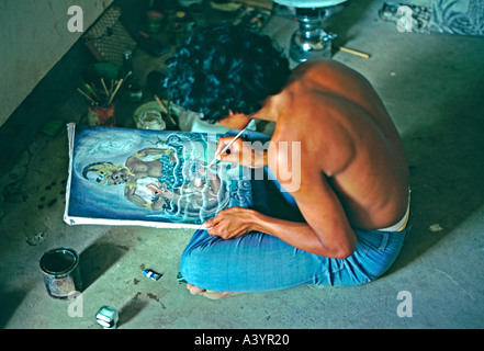 Un artiste balinais dans l'enclave d'œuvres d'artistes d'Ubud sur une peinture dans un style traditionnel Balinais Banque D'Images