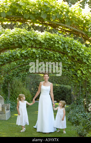 Deux jeunes filles et young bride ivy sous les arches, holding hands, portrait Banque D'Images