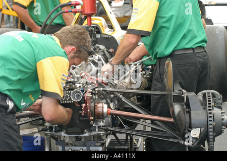 Mécaniciens travaillant sur le moteur de voiture de course Banque D'Images