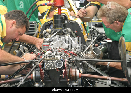 Équipe de mécaniciens travaillant sur le moteur de voiture de course Banque D'Images