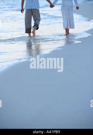 Couple en train de marcher le long d'une plage Banque D'Images
