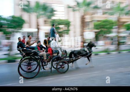 Un groupe de jeunes hommes dans une calèche sur la voie d'une fête de mariage à Louxor en Égypte Banque D'Images