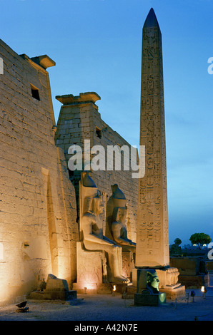 Le magnifique temple de Louxor au crépuscule avec des statues colossales de Ramsès II et d'un obélisque en face de l'entrée des pylônes électriques Banque D'Images