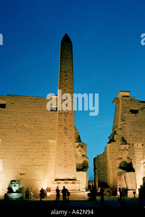 Le magnifique temple de Louxor au crépuscule avec des statues colossales de Ramsès II et d'un obélisque en face de l'entrée des pylônes électriques Banque D'Images