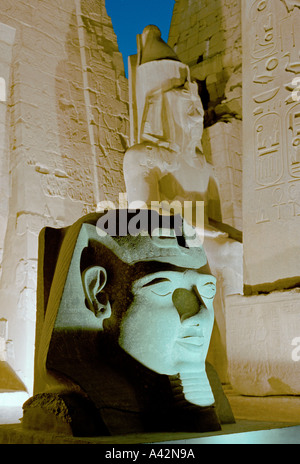 Le magnifique temple de Louxor au crépuscule avec des statues colossales de Ramsès II et d'un obélisque en face de l'entrée des pylônes électriques Banque D'Images