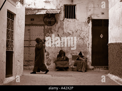 Deux vieillards assis sur le sol et d'une femme avec des vêtements traditionnels de la médina de Tanger Maroc Afrique du Nord Banque D'Images