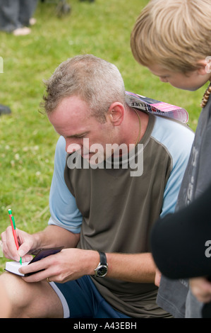 DJ Norman Cook aka Fatboy Slim signant son autographe pour un admirateur après avoir participé à une course de bienfaisance Brighton UK Banque D'Images