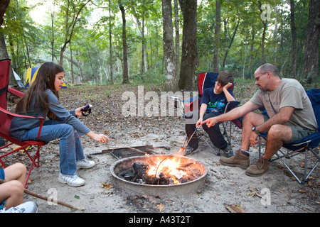 Assis autour de la famille des smores de camp à Manatee Springs State Park à Chiefland, Floride Banque D'Images