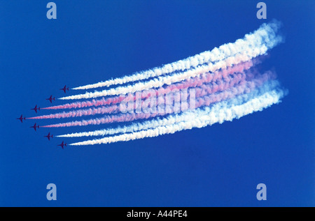 RAF Des flèches rouges display team en silhouette battant sept jets dans une formation serrée forme flèche avec traces de fumée Banque D'Images