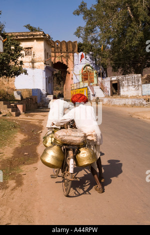 Inde Rajasthan Bundi milkmen poussant leurs vélos chargés par l'ancienne porte à Jait Segar Lake Banque D'Images