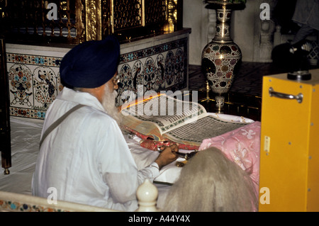 Un Sikh lit depuis le saint livre à l'intérieur du temple d'or à Amritsar, Punjab, India Banque D'Images