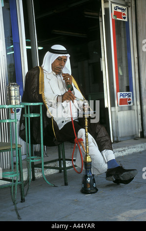 Fumeurs de narguilé en Jordanie. Un homme arabe locale fume la pipe à eau traditionnelle dans un petit café dans le Nord de la Jordanie Banque D'Images