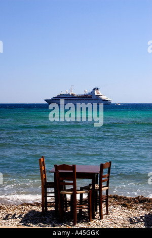 Table de salle à manger privée près de la mer avec un bateau de croisière dans l'arrière-plan Banque D'Images