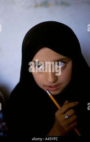 Une jeune fille portant un hijab apprend à lire dans une classe Kaboul, Afghanistan Banque D'Images