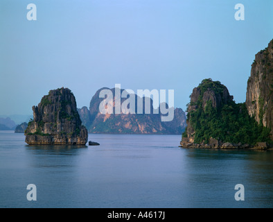 VIETNAM Asie du sud-est au nord de la baie de Ha Long îles calcaires karstiques passant de plantes vertes en mer rock face Banque D'Images