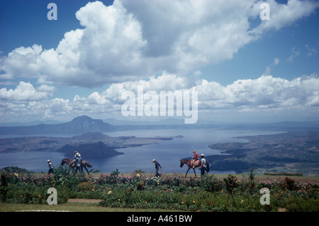 Asie du sud-est de l'île de Luzon aux Philippines le lac Taal touristes menée sur les chevaux le long de rives du lac de cratère volcanique dormante Banque D'Images