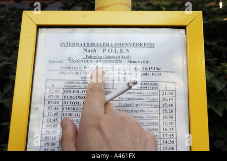 Calendrier des arrivées de bus et une main avec une cigarette, Allemagne Banque D'Images