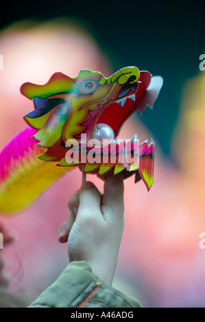 Papier Jouets dragon chinois en équilibre sur des doigts de jeune garçon, Nouvel An Eaton, Chinatown, Londres, Angleterre, Royaume-Uni Banque D'Images