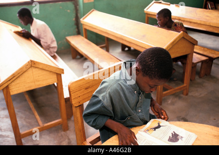Un enfant lit un livre dans une bibliothèque dans une école dirigée par le projet Youth Alive à Tamale, dans le Nord du Ghana Banque D'Images