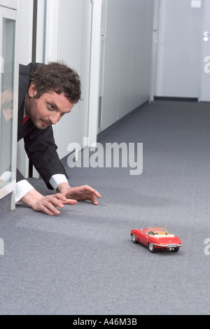 Businessman Playing with toy car Banque D'Images