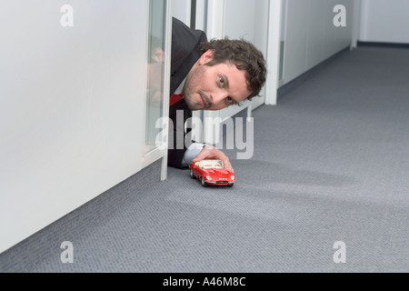 Businessman Playing with toy car Banque D'Images
