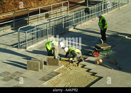 Les ouvriers de Londres et de levage des dalles de béton rebedding Banque D'Images
