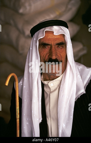 Un vieil homme vêtu d'une robe arabe traditionnel keffieh (kufiya) et une thobe et bâton de marche dans la région de Baalbek, au Liban Banque D'Images