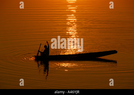 Le coucher du soleil est pêcheur La pêche dans son bateau de pêche dans le Mékong Vientiane Laos Banque D'Images