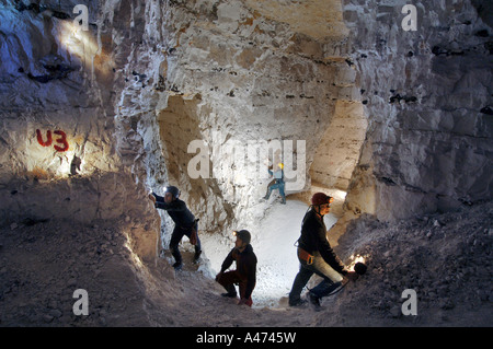 Un groupe de quatre spéléos explorer le réseau des mines de craie sous Lecture à Berkshire Banque D'Images