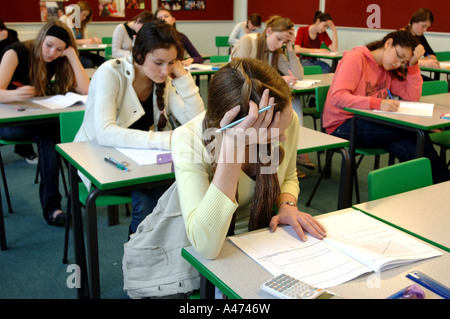 Une adolescente se concentrant dur dans une salle d'examen Banque D'Images