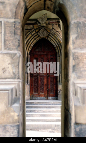 Vue à travers une arche en pierre et des escaliers sur une porte en bois au Château de Prague en République Tchèque Banque D'Images