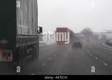 De mauvaises conditions de conduite dans la neige et les conditions météorologiques humides vu à travers le pare-brise de voiture autoroute britannique, England, UK Banque D'Images