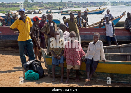 Scène au bord de bateaux de pêche et de ferry-boat, les garçons par l'eau sur les rives du lac Albert, dans le Nord de l'Ouganda, Afrique E Banque D'Images