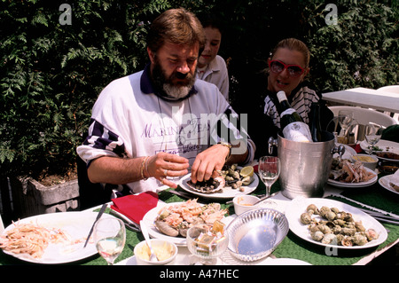 Constructeur britannique Chris Pearson et la famille d'avoir un déjeuner de fruits de mer dans le jardin en France Banque D'Images