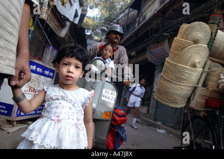 Une jeune Indienne tient la main de son père dans une rue de New Delhi en Inde. Banque D'Images