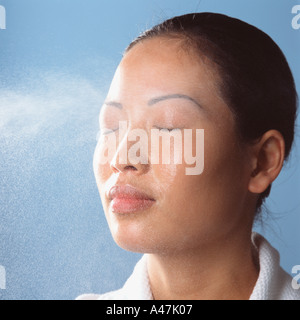 Pulvérisation d'eau sur le visage de femme Banque D'Images