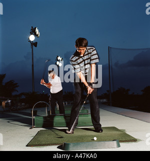 Les hommes pratiquant sur driving range Banque D'Images