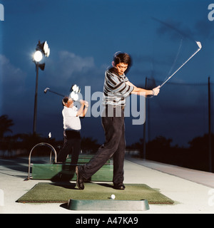 Les hommes pratiquant sur driving range Banque D'Images