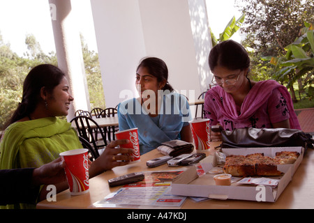 Les jeunes femmes indiennes qui travaille dans l'industrie pour Infosys mange fast food de l'ouest durant une pause-déjeuner à Bangalore en Inde Banque D'Images