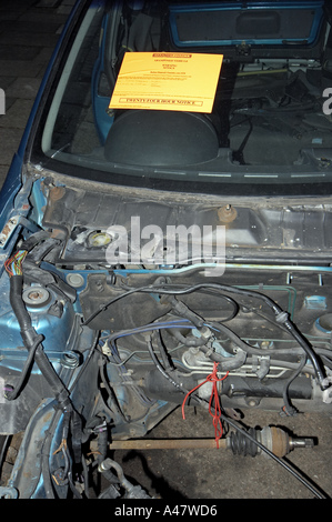 Vauxhall bleu abandonné et vandalisé des pièces de voiture accidentée à gauche sur la banlieue de Londres avec l'élimination de la rue Conseil d'avertissement Banque D'Images