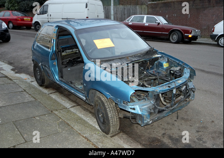 Vauxhall bleu abandonné et vandalisé des pièces de voiture accidentée à gauche sur la banlieue de Londres avec l'élimination de la rue Conseil d'avertissement Banque D'Images
