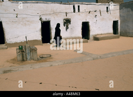 Une femme marche nubien de l'autre côté de la cour dans Village nubien atypique.Assouan Nil Egypte Banque D'Images