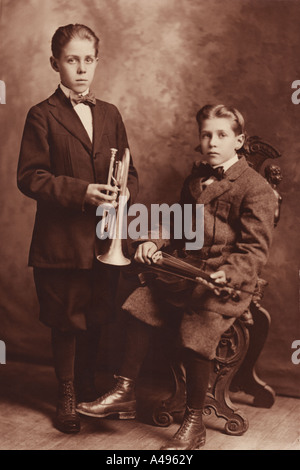 Vers 1880 photo de deux garçons avec des instruments de musique. Banque D'Images