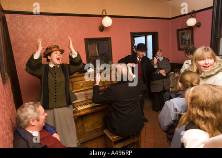 UK Shropshire Shifnal Blists Hill Victorian Town New Inn Noël traditionnel de chansons autour du piano Banque D'Images