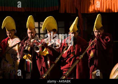 Inde Ladakh Leh Valley festival Spitok Gompa casquette jaune moines soufflant longues cornes Banque D'Images