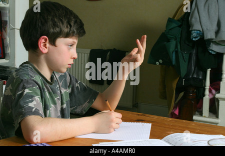 Un garçon de huit ans de faire faire ses devoirs de mathématiques à domicile, février 2006. Banque D'Images