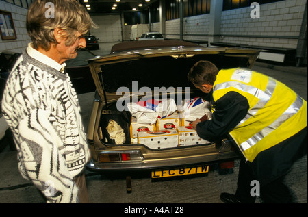 Un AGENT DES DOUANES ET ACCISE, port de Douvres SUR LA CÔTE SUD DE L'ANGLETERRE on confisque les biens des catalogues d'un passeur. Banque D'Images