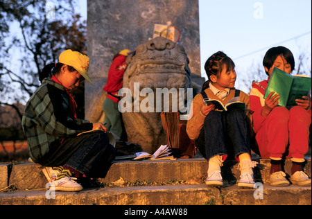 Pékin, Chine : les enfants de l'école faire leurs devoirs sur les marches les Tombeaux des Ming au coucher du soleil Banque D'Images